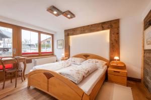 a bedroom with a wooden bed and a dining room at Roses Landhaus in Vorderhornbach