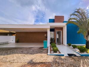 a house with a blue wall and a palm tree at Casaazulvaleparaiba in Jacareí
