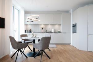 a kitchen and dining room with a table and chairs at Laya Living Lucerne - Kriens in Lucerne