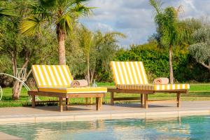two chairs sitting next to a swimming pool at Maison soli Marrakech in Bou Khaoua