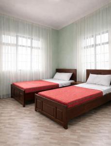 two beds sitting in a room with windows at Oltare Safari Homestay in Makuyuni