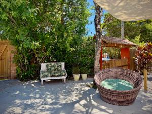 a backyard with a chair and a hot tub at Pousada Pássaros Park in Itapoa