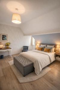 a bedroom with a large bed with a bench at the end at La Bayardine in Sarlat-la-Canéda