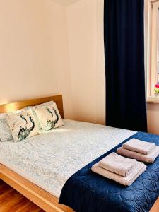 a bedroom with a bed with towels on it at Lux Corner Park przestronne mieszkanie z klimatyzacją, balkonem i podziemnym garażem in Pruszków