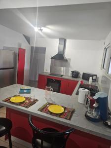 a kitchen with red cabinets and yellow plates on a counter at Le paille en queue in Saint-Pierre +6 photos