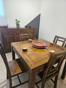 a wooden table with two chairs and a table with a bowl at Le paille en queue in Saint-Pierre