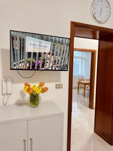 a room with a clock and a vase of flowers on a counter at B&B Torrebianca in Aversa
