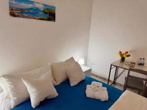 a bed with white pillows and two towels on it at B&B Torrebianca in Aversa