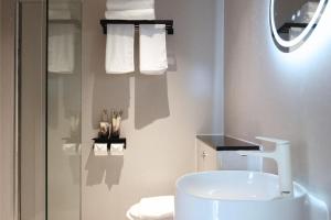 a bathroom with a sink and a toilet and towels at Asphodel Inn - Newly Renovated in Singapore +52 photos