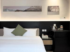 a bedroom with a white bed with a black headboard at Asphodel Inn - Newly Renovated in Singapore