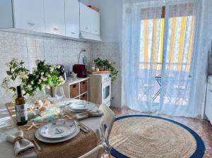 a kitchen with a table with plates and a bottle of wine at Lunigiana e Mare in Aulla