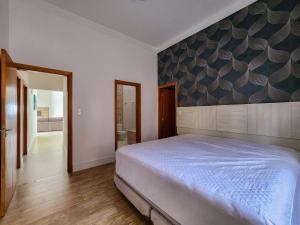a bedroom with a large bed and a hallway at Casaazulvaleparaiba in Jacareí +52 photos