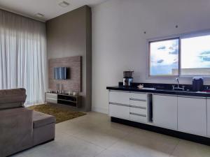a kitchen with a sink and a couch and a window at Casaazulvaleparaiba in Jacareí