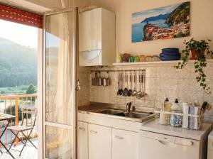 a kitchen with a sink and a balcony at Lunigiana e Mare in Aulla
