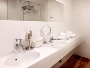 a white bathroom with two sinks and a mirror at Arctic Panorama Lodge in Uløybukta +43 photos