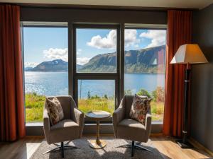 two chairs and a table in front of a large window at Arctic Panorama Lodge in Uløybukta