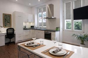 a kitchen with white cabinets and a table with wine glasses at Das Zollhaus Studio Newton nahe der Schweiz in Klettgau in Klettgau