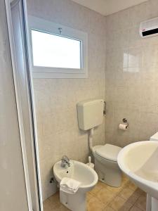a bathroom with a toilet and a sink and a window at Villa Bruna B&B in Sanremo +15 photos