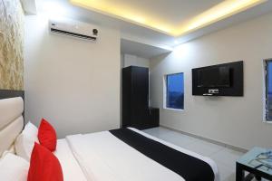 a bedroom with a bed and a tv on the wall at Hotel Aroma Regency in Meerut