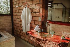a bathroom with a glass bowl on a stone sink at Pousada Peterle in Domingos Martins