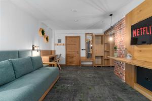 a living room with a blue couch and a brick wall at Forest Green & Spa in Gura Humorului