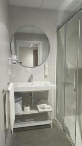 a bathroom with a sink and a shower at Apartamentos O Caneiro in Portomarin
