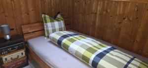 a bed in a wooden room with two pillows at Wohnung in Reichenbach im Kandertal in Reichenbach