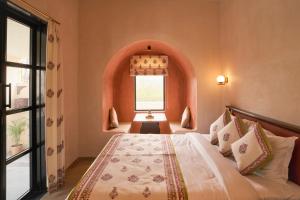 a bedroom with a large bed with a window at Niwasa - A Luxury Boutique Stay, Udaipur in Udaipur +23 photos