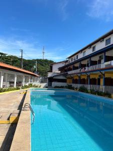 a large swimming pool in front of a building at Apartamento com sala e cozinha no morro da saudade in Morro de São Paulo