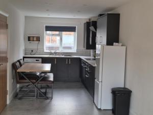 a small kitchen with a table and a refrigerator at Brigg new build home in Brigg