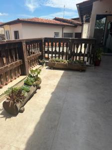 a patio with a wooden fence and potted plants at Suíte Refúgio das Suculentas Master Confort in Socorro