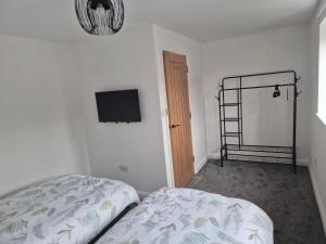 a bedroom with a bed and a flat screen tv at Brigg new build home in Brigg
