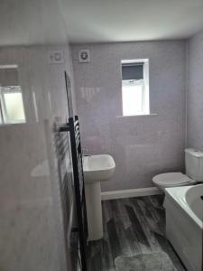 a bathroom with a sink and a toilet and a window at Brigg new build home in Brigg +2 photos