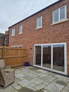 a patio with sliding glass doors in front of a brick building at Brigg new build home in Brigg