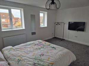 a bedroom with a bed and a flat screen tv at Brigg new build home in Brigg