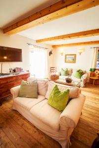 a living room with a white couch with green pillows at Chalet Gulas - La Punt-Chamues-ch in La Punt-Chamues-ch +22 photos