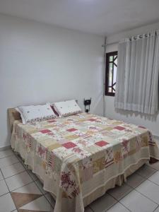 a bedroom with a bed with a quilt on it at Casa Baraúnas 05 in Gravatá +20 photos