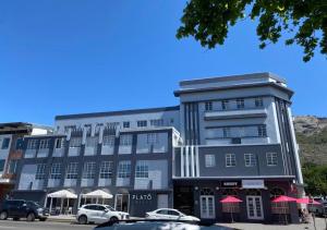 a large building with cars parked in front of it at Melk Tert - Paarl - Self Catering Apartment in Paarl