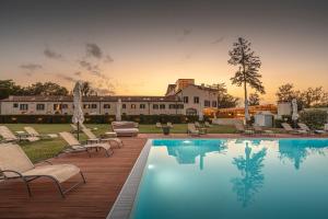 a pool with chairs and a house in the background at Hotel Villa Barbarich in Mestre