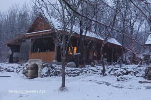 a log cabin in the snow in front at Hidden Garden Kide (Chidea) in Cluj-Napoca