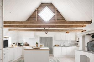 an attic kitchen with white cabinets and a skylight at Smålandstorpets lanthotell in Hok