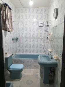 a bathroom with a blue toilet and a sink at Kandy Nest Stay Home in Kandy