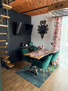 a dining room with a table and green chairs at Domek w górach in Załuczne