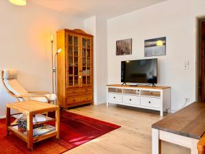 a living room with a flat screen tv and a table at Seenest 'Paradies' mit Parkplatz in Konstanz