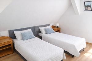 two beds in a small room with white walls at Dom Przyjaźni in Kędzierzyn-Koźle