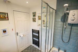 a bathroom with a shower with a glass door at Chapel Bricks in Withernwick +39 photos