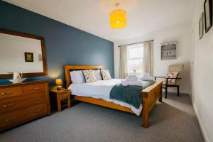 a bedroom with a bed and a dresser and a window at Chapel Bricks in Withernwick