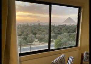 a room with a window with a view of the pyramids at The Nomad Pyramids Boutique Hotel in Cairo