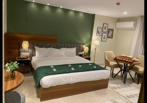 a bedroom with a large bed with a green wall at The Nomad Pyramids Boutique Hotel in Cairo +58 photos
