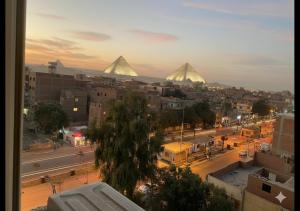 a view of a city with pyramids in the background at The Nomad Pyramids Boutique Hotel in Cairo